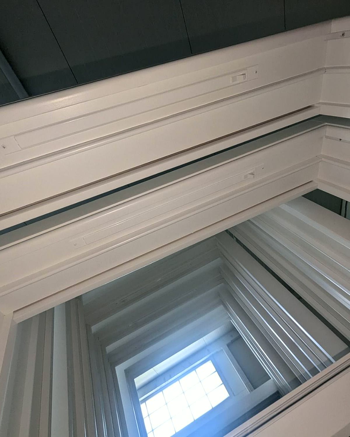 Timber bay window frame seen from inside, showing the mitred head and sections