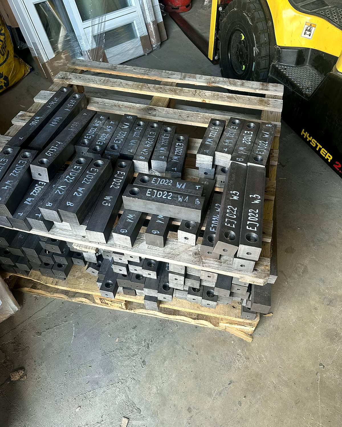 Cast iron sash weights labelled per opening on a pallet