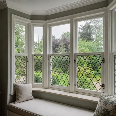 Leaded timber bay window with a window seat overlooking a garden