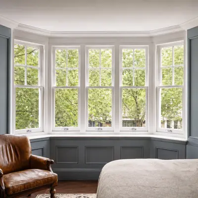 Bedroom bay of white timber sliding sash windows with panelled walls